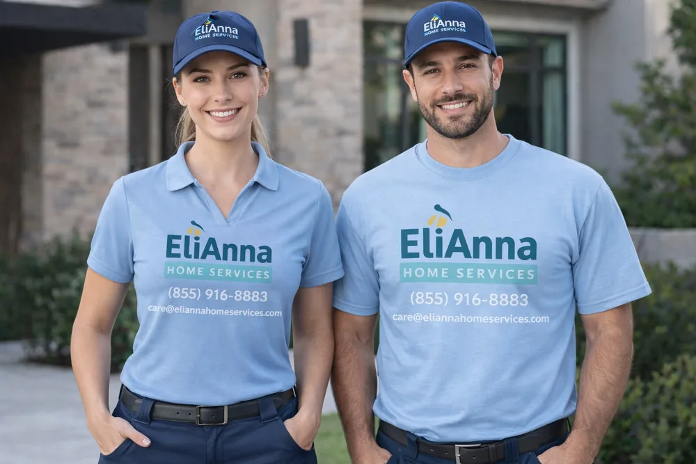 Two uniformed EliAnna Home Services crew members in branded light-blue shirts and navy caps, standing in front of a San Diego home